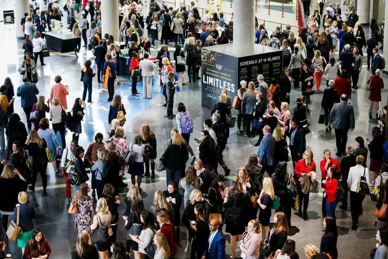 Overhead view of a crowded conference lobby with attendees gathered in small groups.
