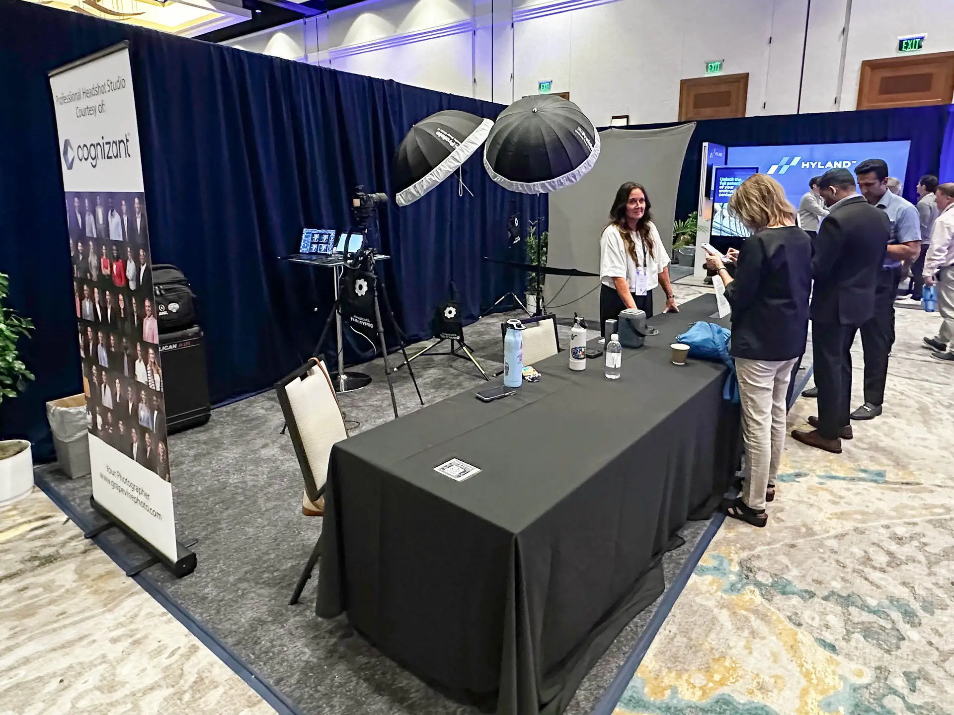Headshot photography booth with a banner reading Professional Headshot Studio Courtesy of Cognizant in a convention hall