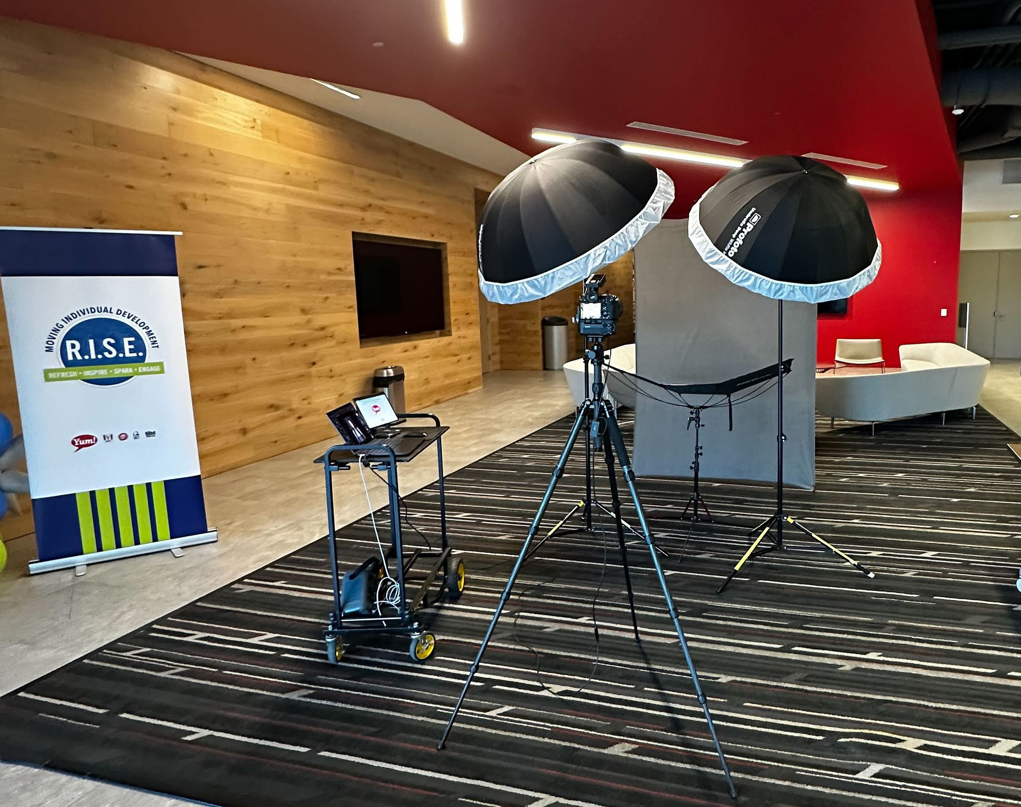 Portrait lighting setup near a R.I.S.E. conference banner in a hotel lobby