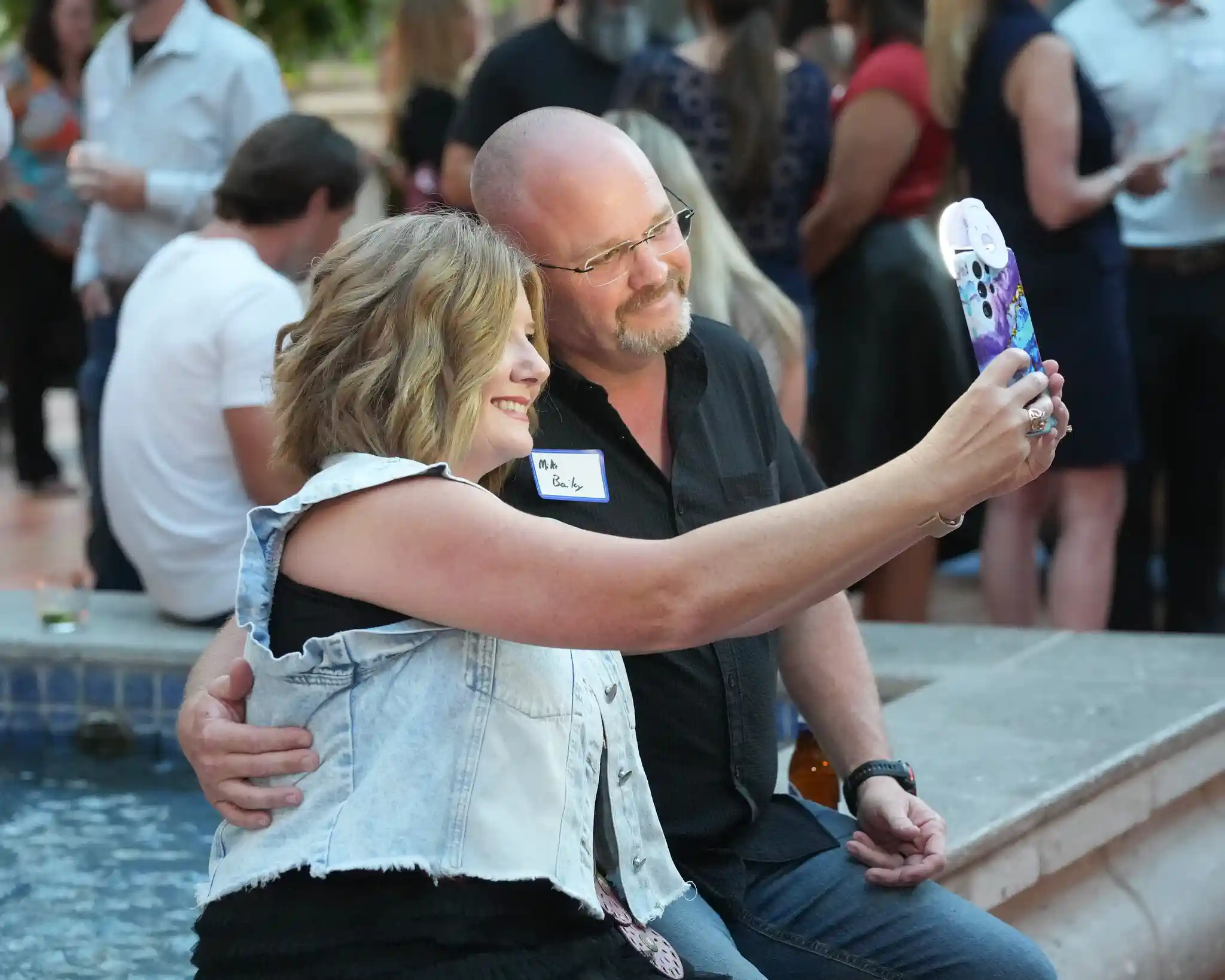 Two guests share a candid selfie beside the water during the Gaylord Texan reception.